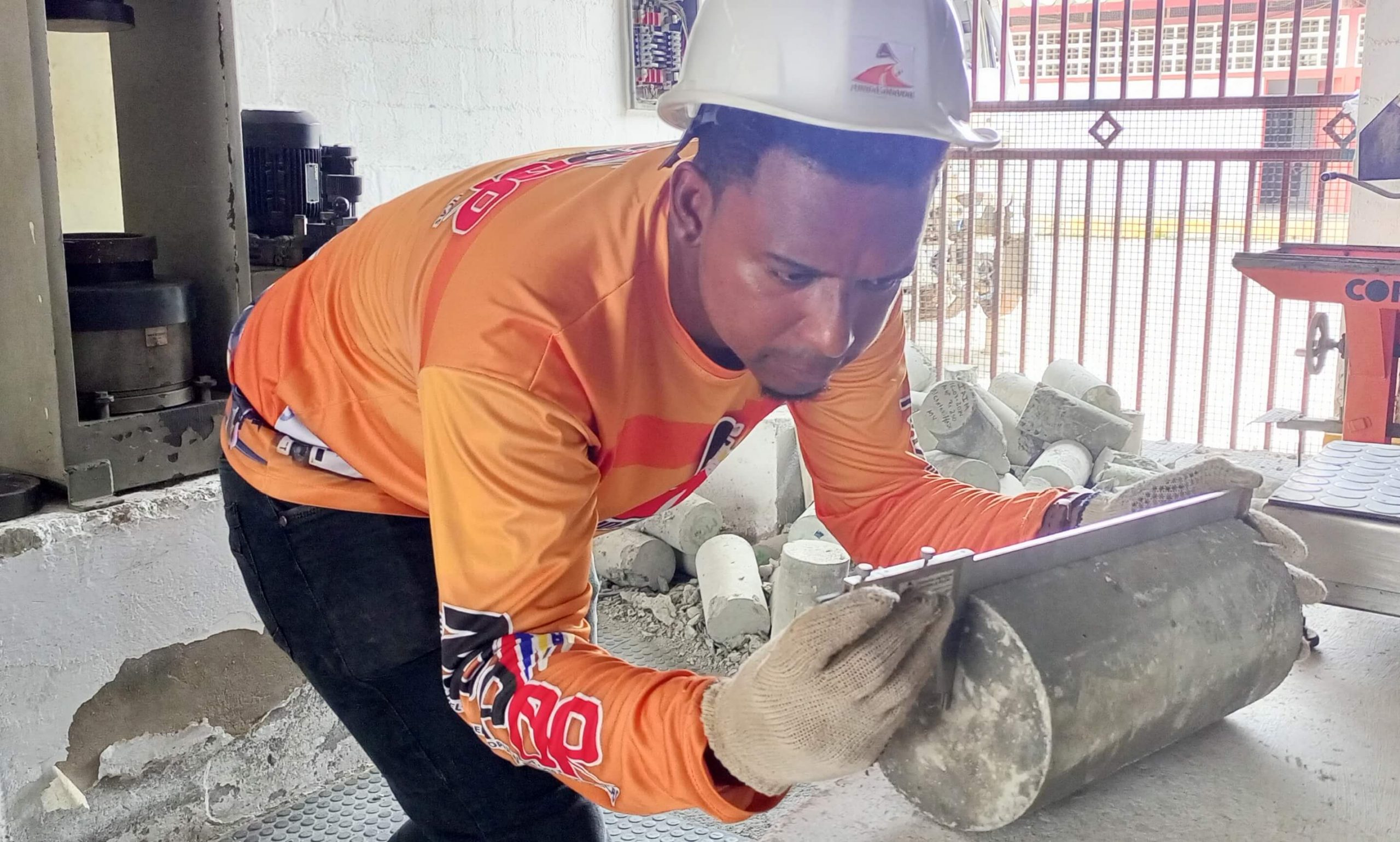trabajador usando vernier en ensayo de cilindros de concreto